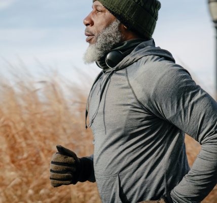 Black man in sportswear jogging in sunny autumn day