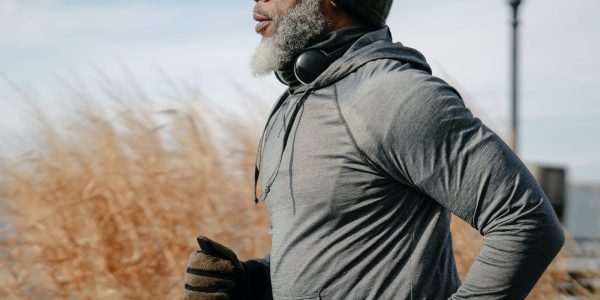 Black man in sportswear jogging in sunny autumn day